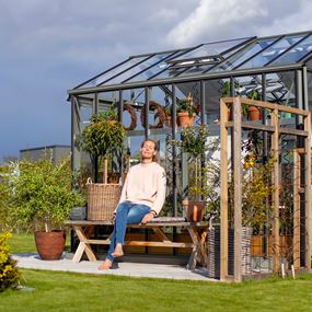 Miljöbild på växthuset Victorian, med solande kvinna framför